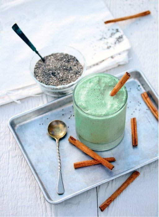 نوشیدنی انرژی زا خانگی چای ماسالا با اسپیرولینا در سینی با چوب دارچین و قاشق در کنار آن